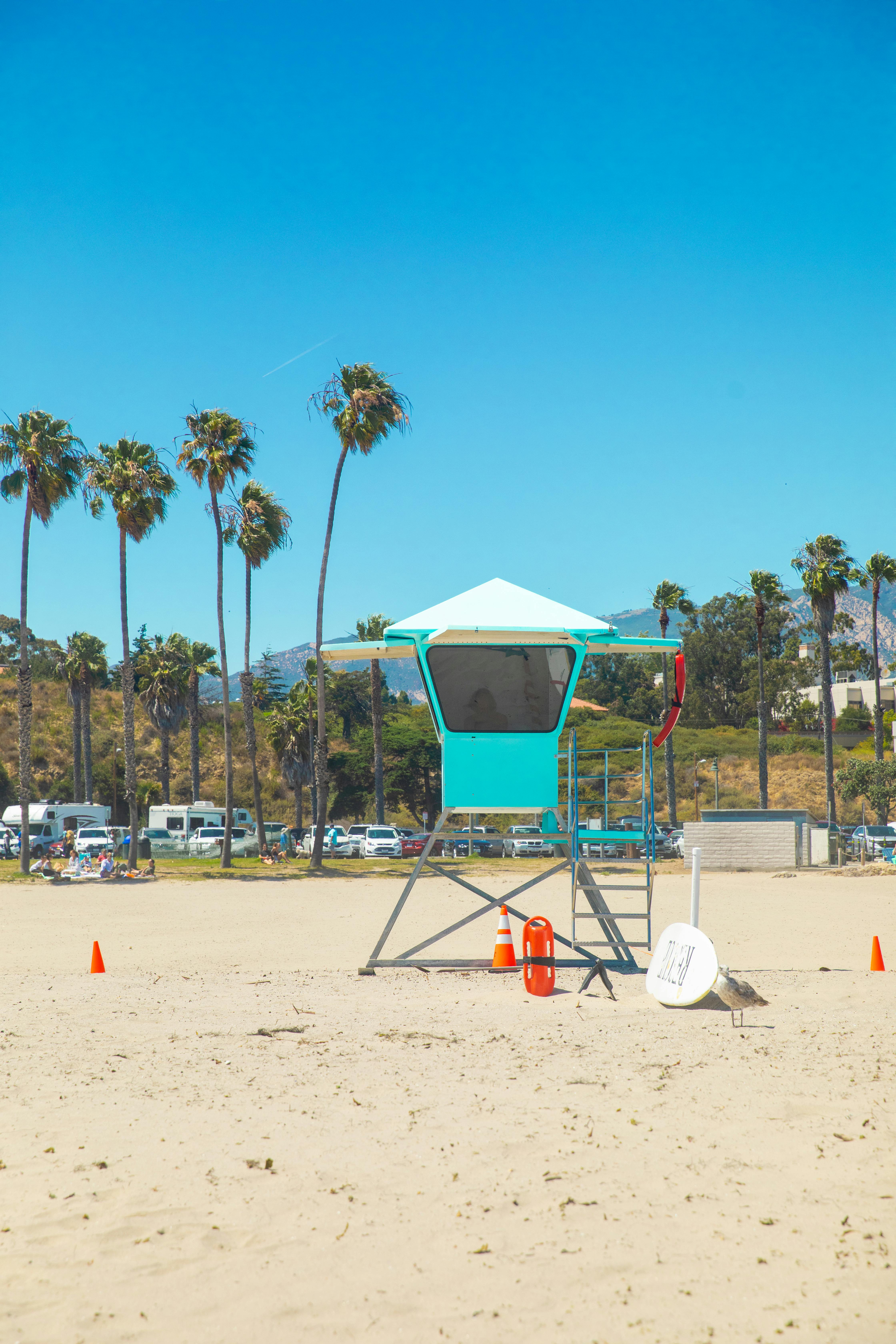 A sunny day at the Santa Barbara beach featuring a lifeguard tower and palm trees.