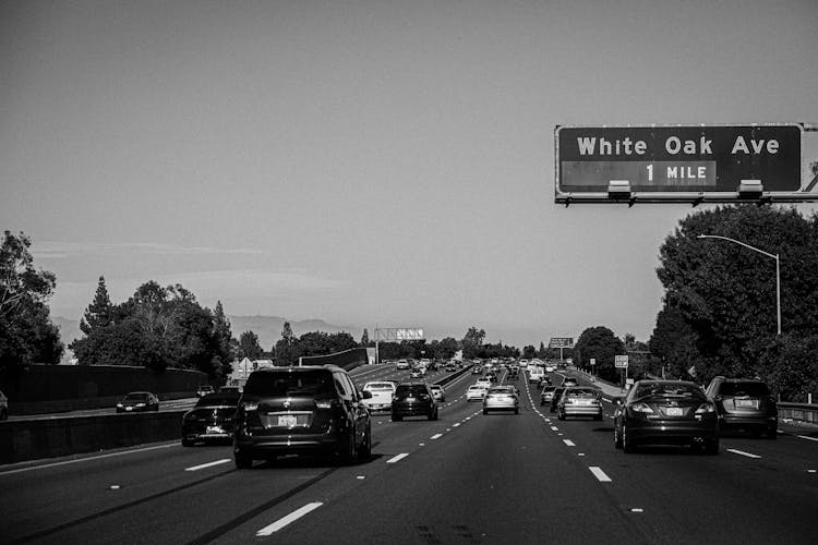 Grayscale Photo Of Cars On Highway With White Oak Ave Signage