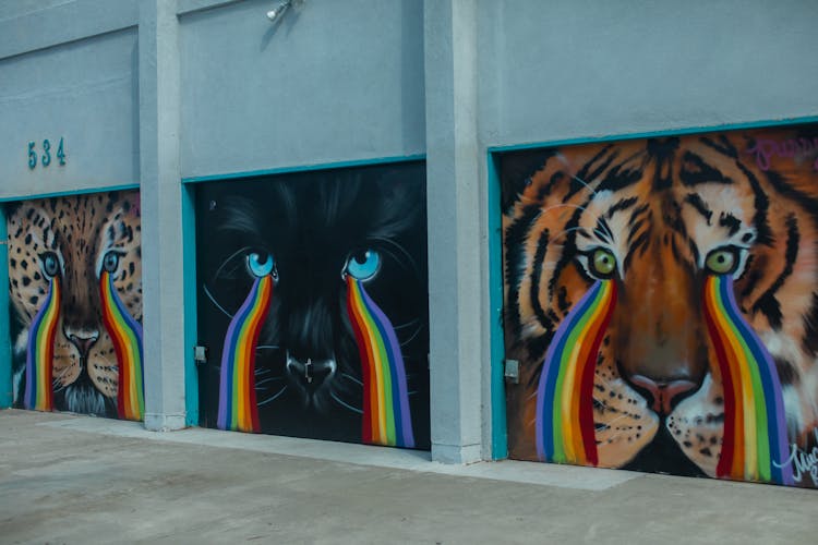 A Wall Painting Of Ferocious Cats Crying Rainbows