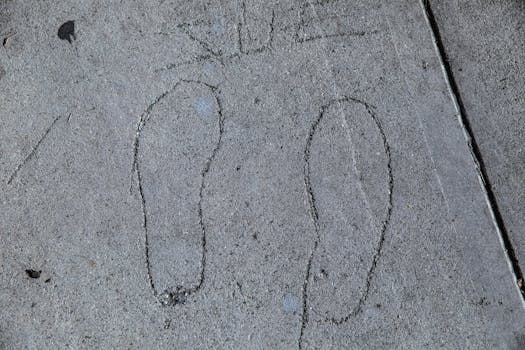 Footprint outlines etched into a concrete sidewalk in Los Angeles.