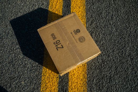 以独特的角度拍摄了黄线标记的道路沥青上的纸板箱