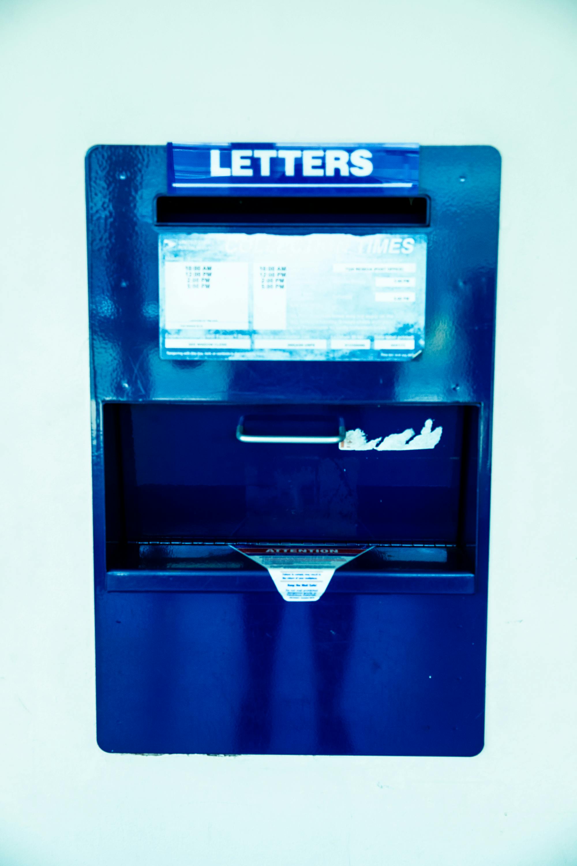 close up photo of a blue metal mailbox on wall