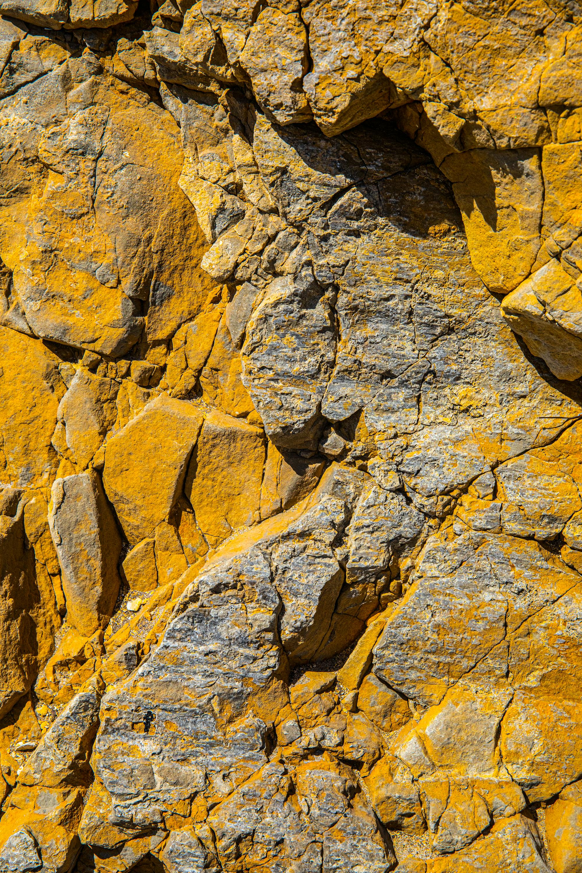 gray rocky surface with yellow stains and cracks