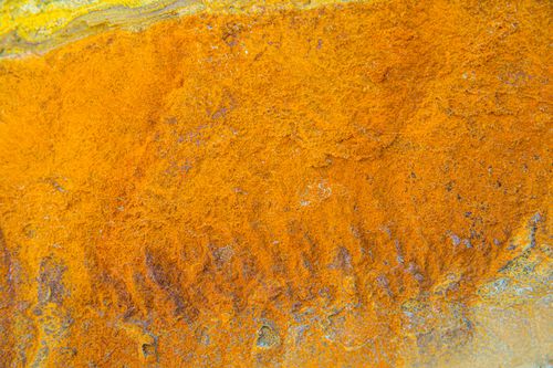 Free Close-up of a vibrant orange rusty texture on a metal surface, displaying interesting patterns and colors. Stock Photo
