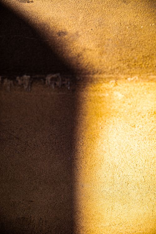 Free Close-up of a textured wall in sunlight, creating an abstract play of shadows in Los Angeles. Stock Photo