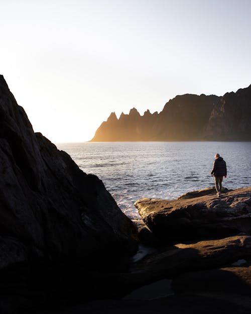 Back View of Person Walking Near the Ocean 