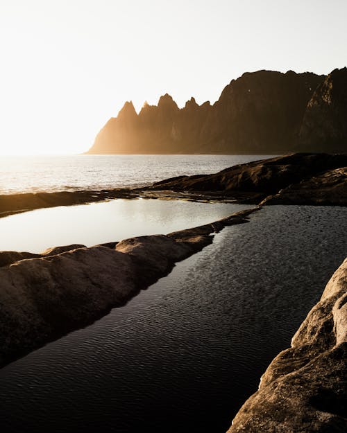 Foto profissional grátis de águas calmas, corpo d'água, formações rochosas