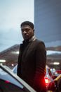 Man in Black Suit Standing Near Cars
