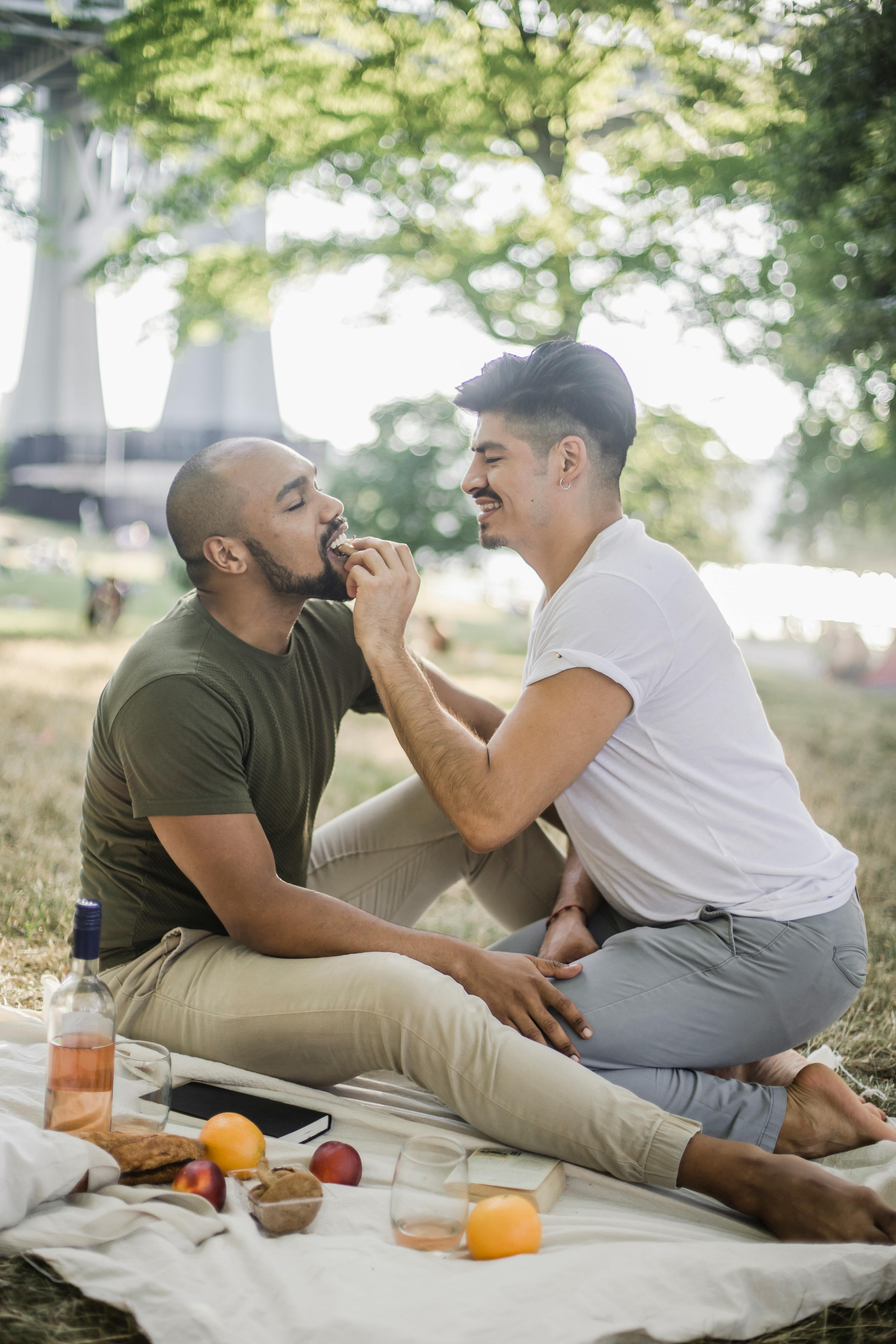 two men having a picnic and being affectionate