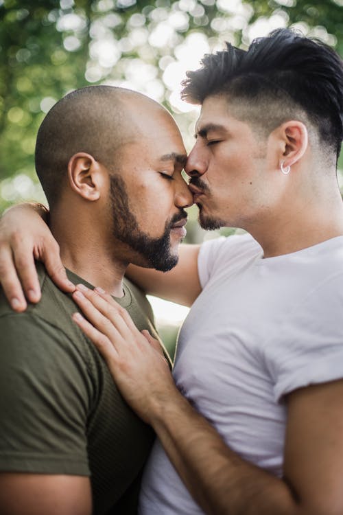 Free Man Kissing Another Man on the Nose Stock Photo
