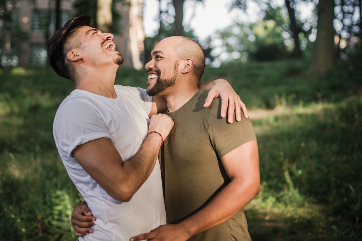 Two men hugging and smiling