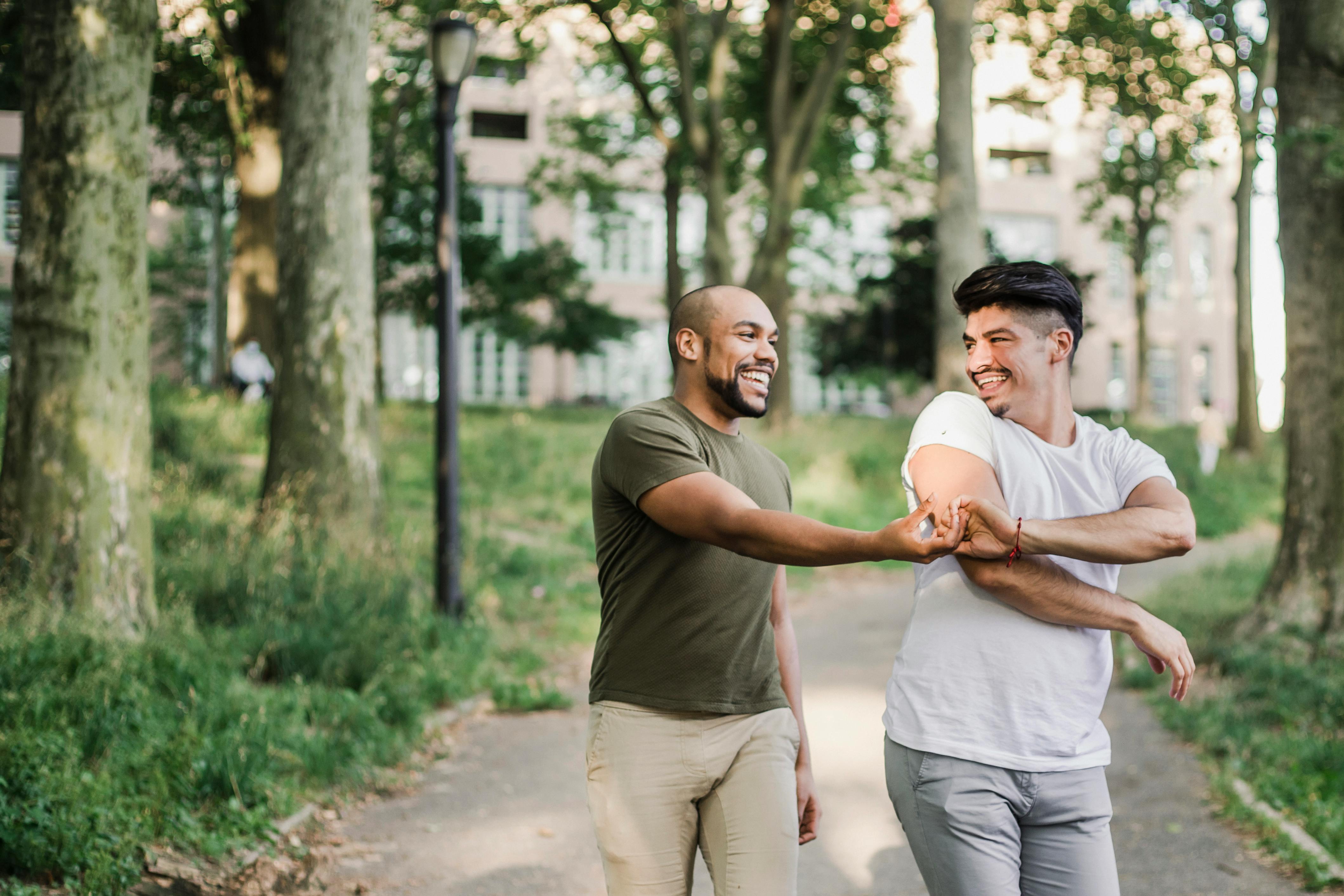 two happy men walking and holding hands