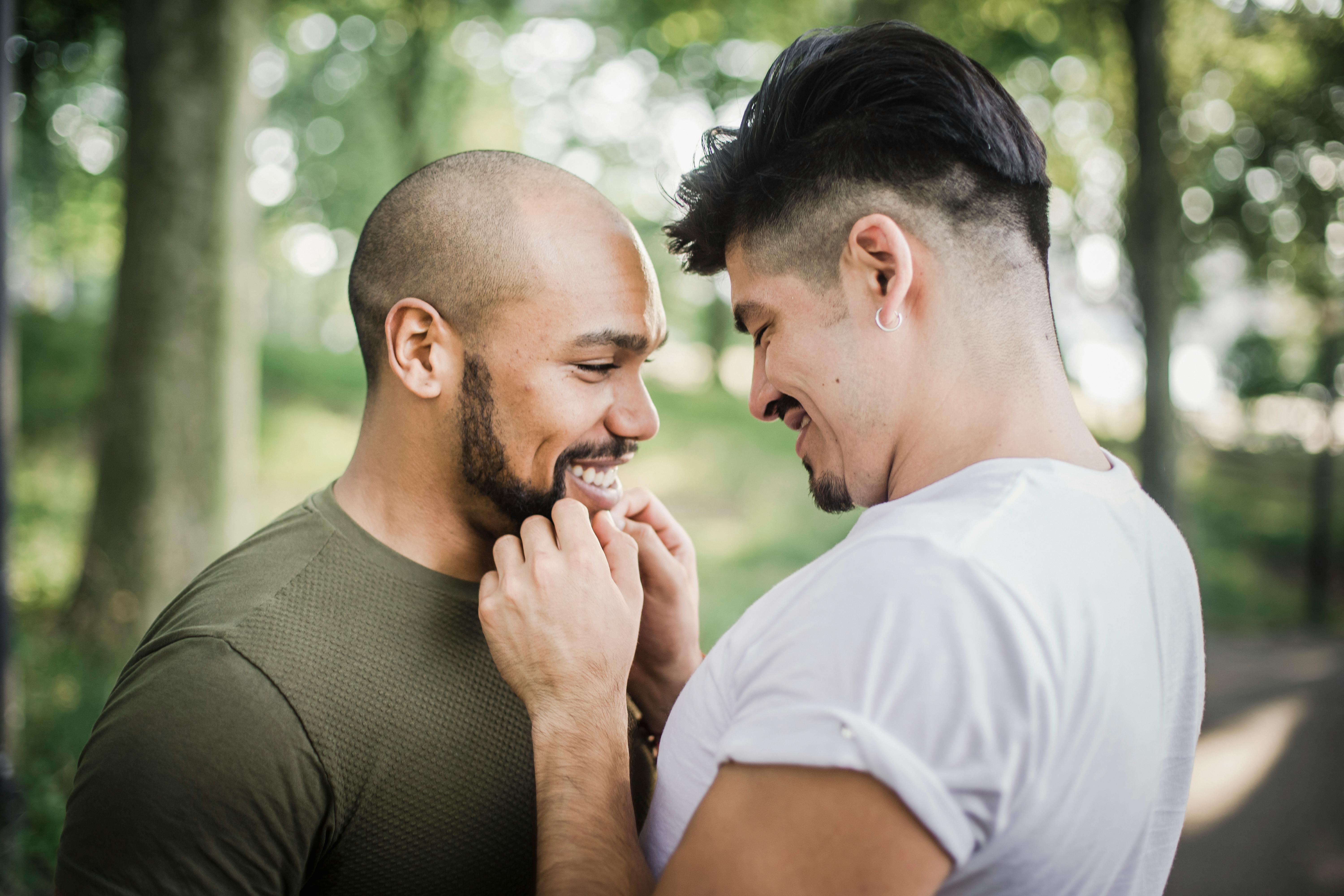 two men smiling and being affectionate