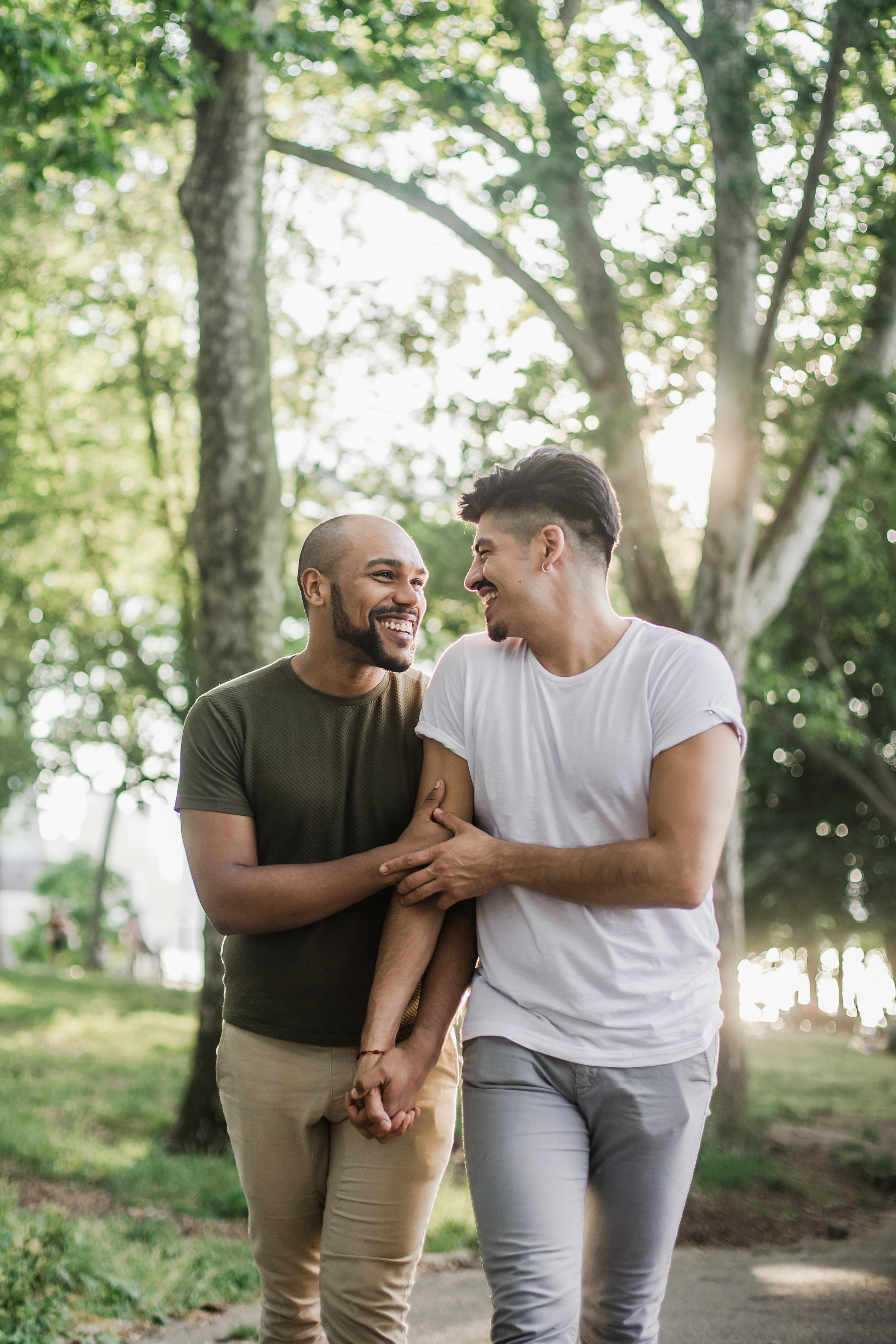 two happy men walking and holding hands