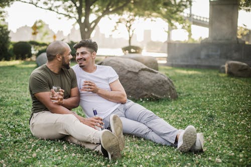 Two Men Sitting on the Grass and Looking at Each Other