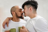 两名男子在明亮的环境中亲密地分享一杯咖啡