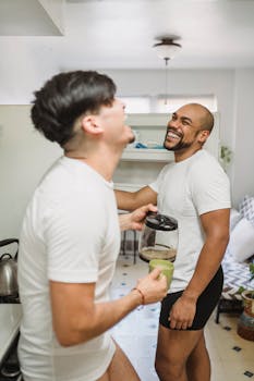 一对幸福的夫妇在厨房里笑着喝咖啡，共度清晨时光