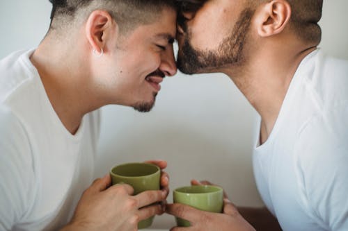 Free Man Kissing Another Man on the Forehead Stock Photo