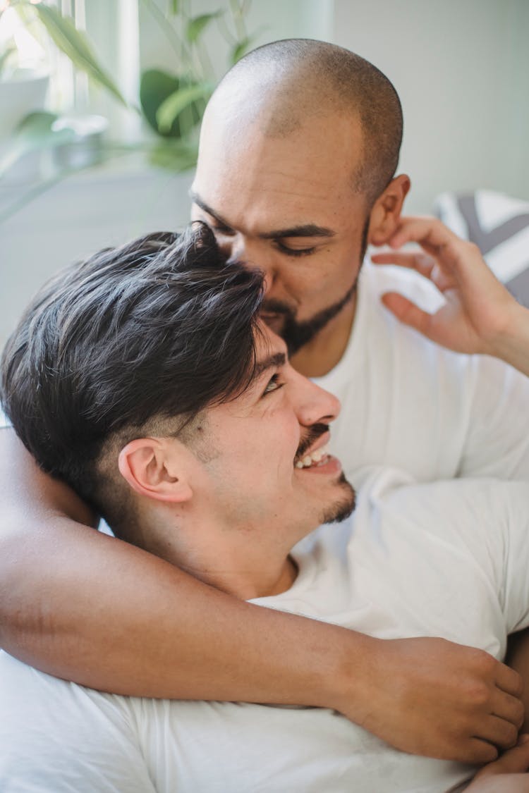 Bearded Man Hugging And Kissing His Partner On Head