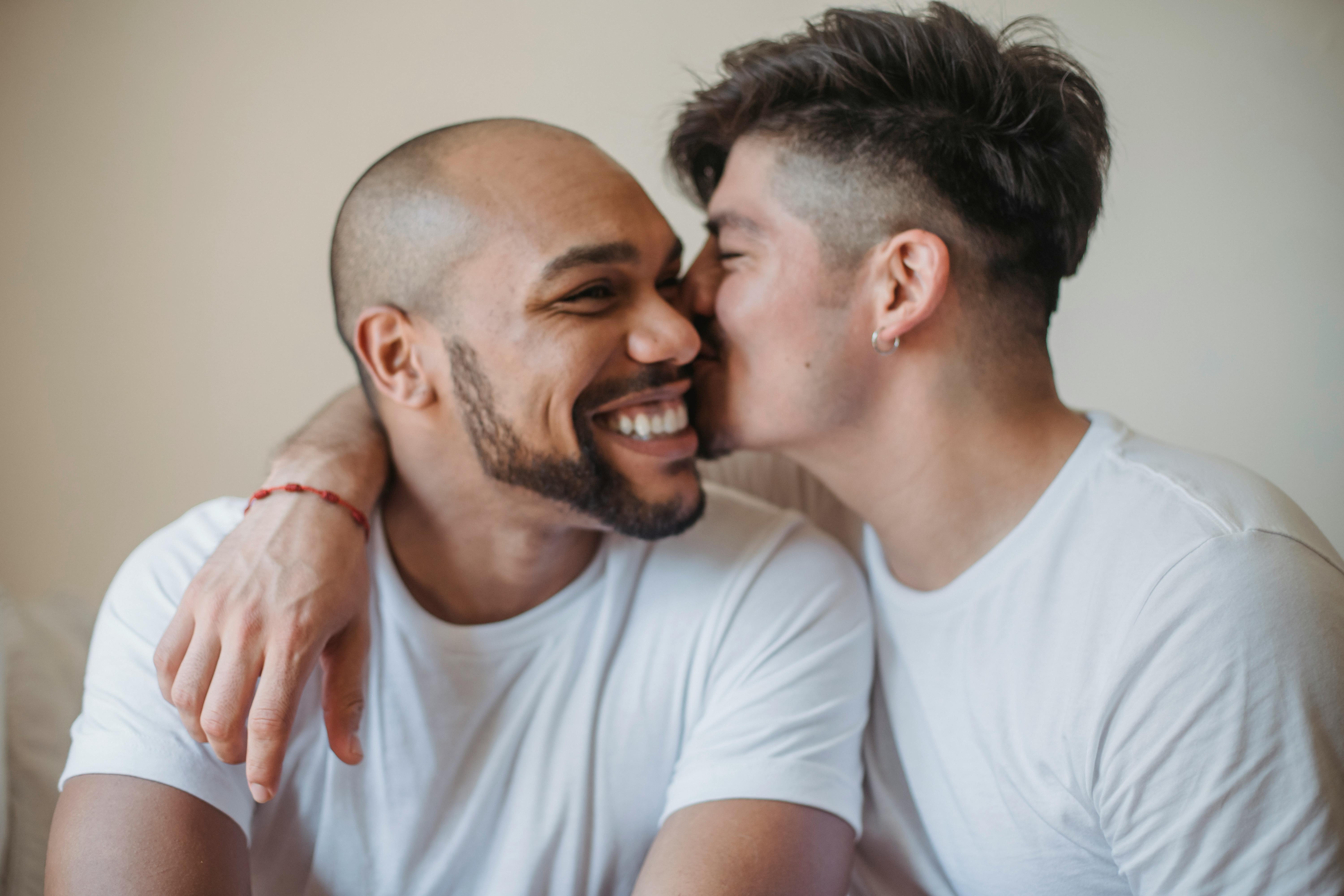 man kissing another man on the cheek