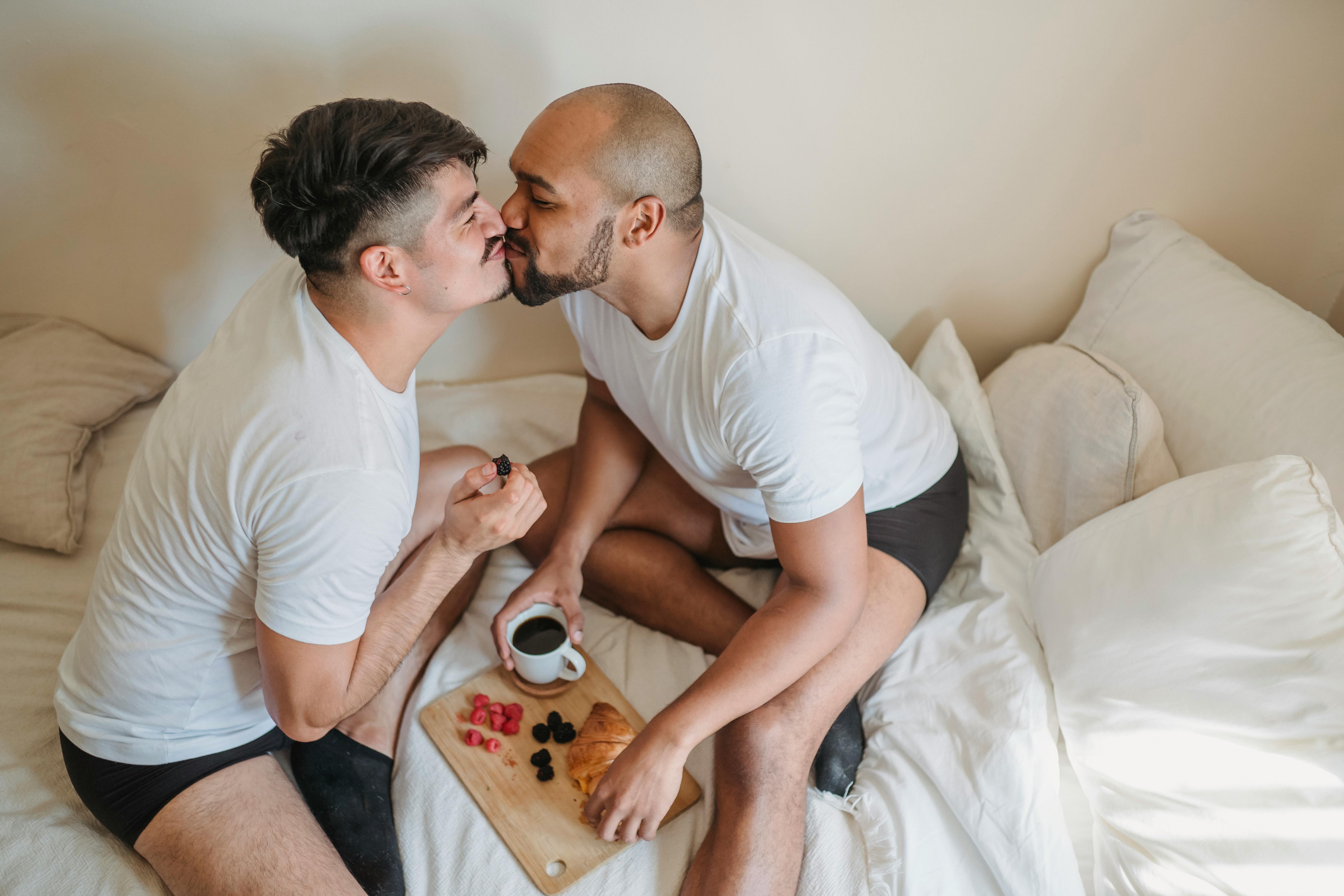 two men having breakfast and kissing