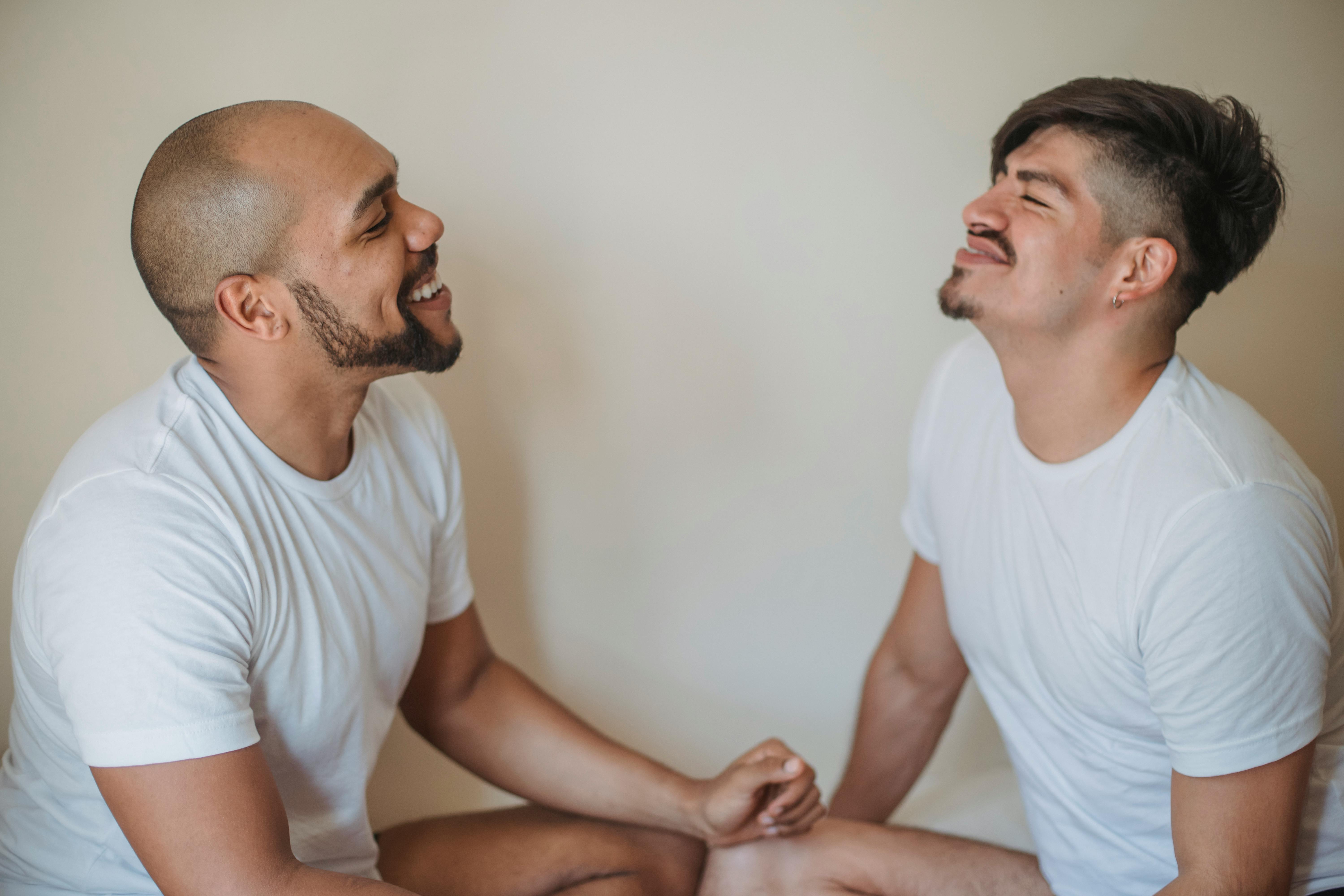 two men sitting opposite each other and smiling