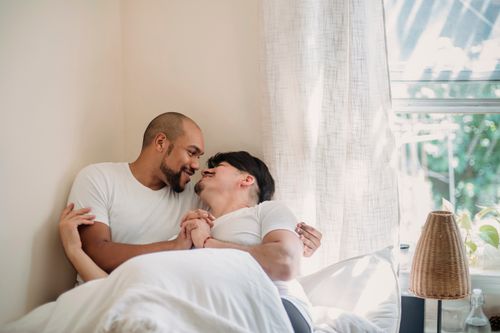 Free A tender moment shared between a loving couple cuddling in a cozy bedroom. Stock Photo