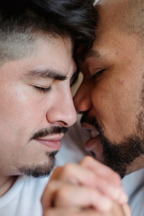 Free Couple Holding Hands and Standing with Their Faces Very Close to Each Other Stock Photo