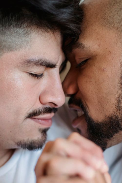 Free Close-up image of two men embracing with eyes closed, expressing love and affection. Stock Photo