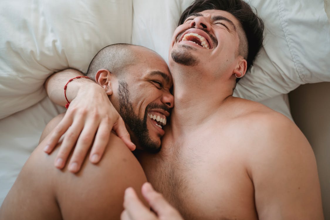 Topless Men Lying on Bed