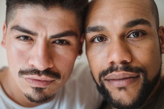 Intimate close-up portrait of two diverse men expressing thoughtful contemplation.