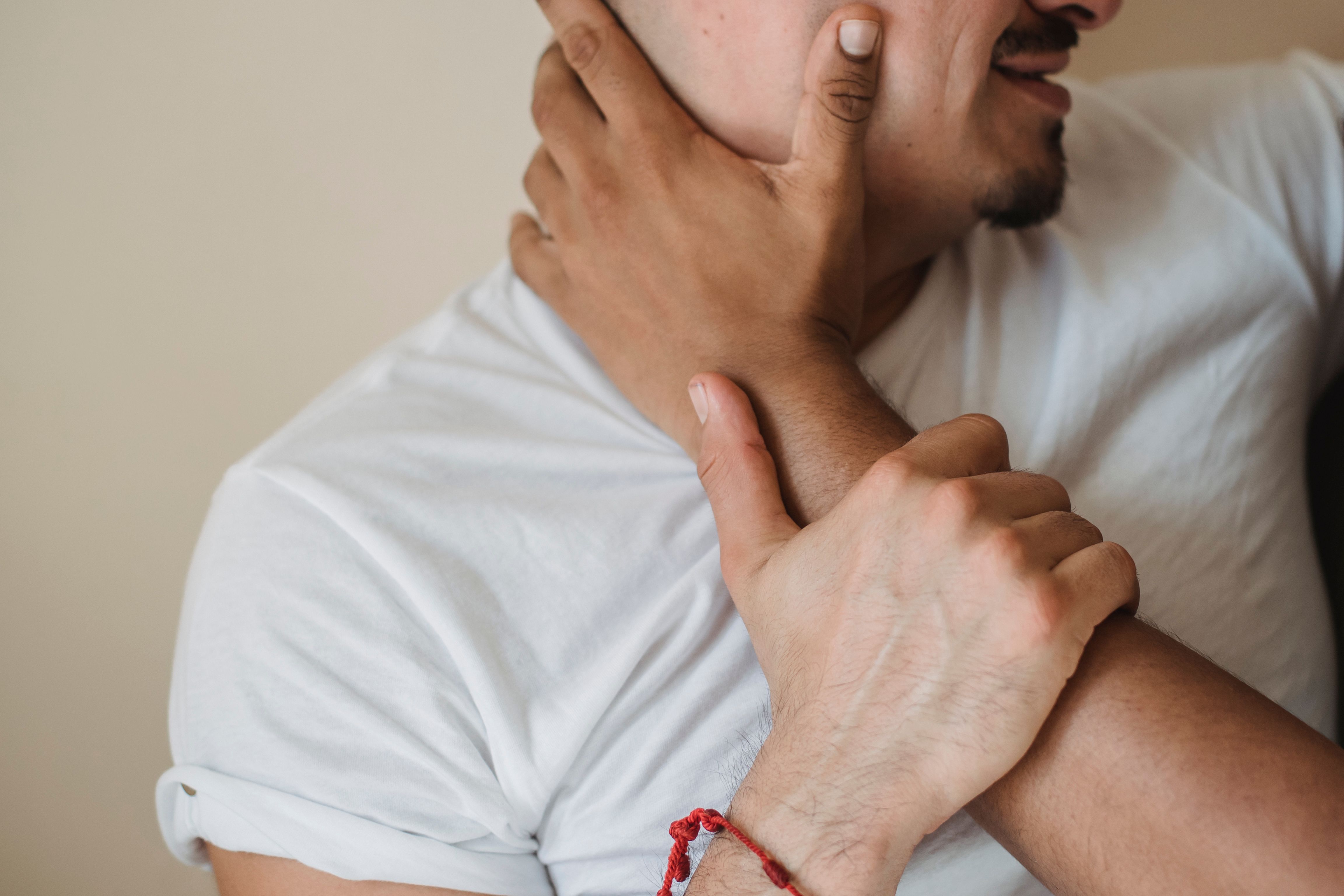 Close-up of a couple embracing intimately, focusing on hands and facial expression.