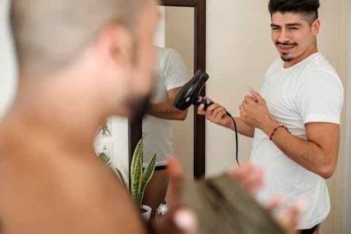 Man Looking at His Boyfriend While He is Drying His Hair 