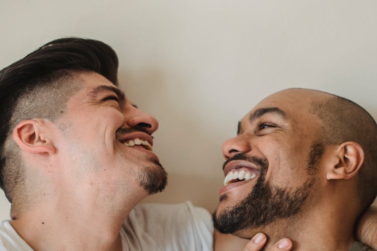 Portrait Of Two Men Smiling At Each Other