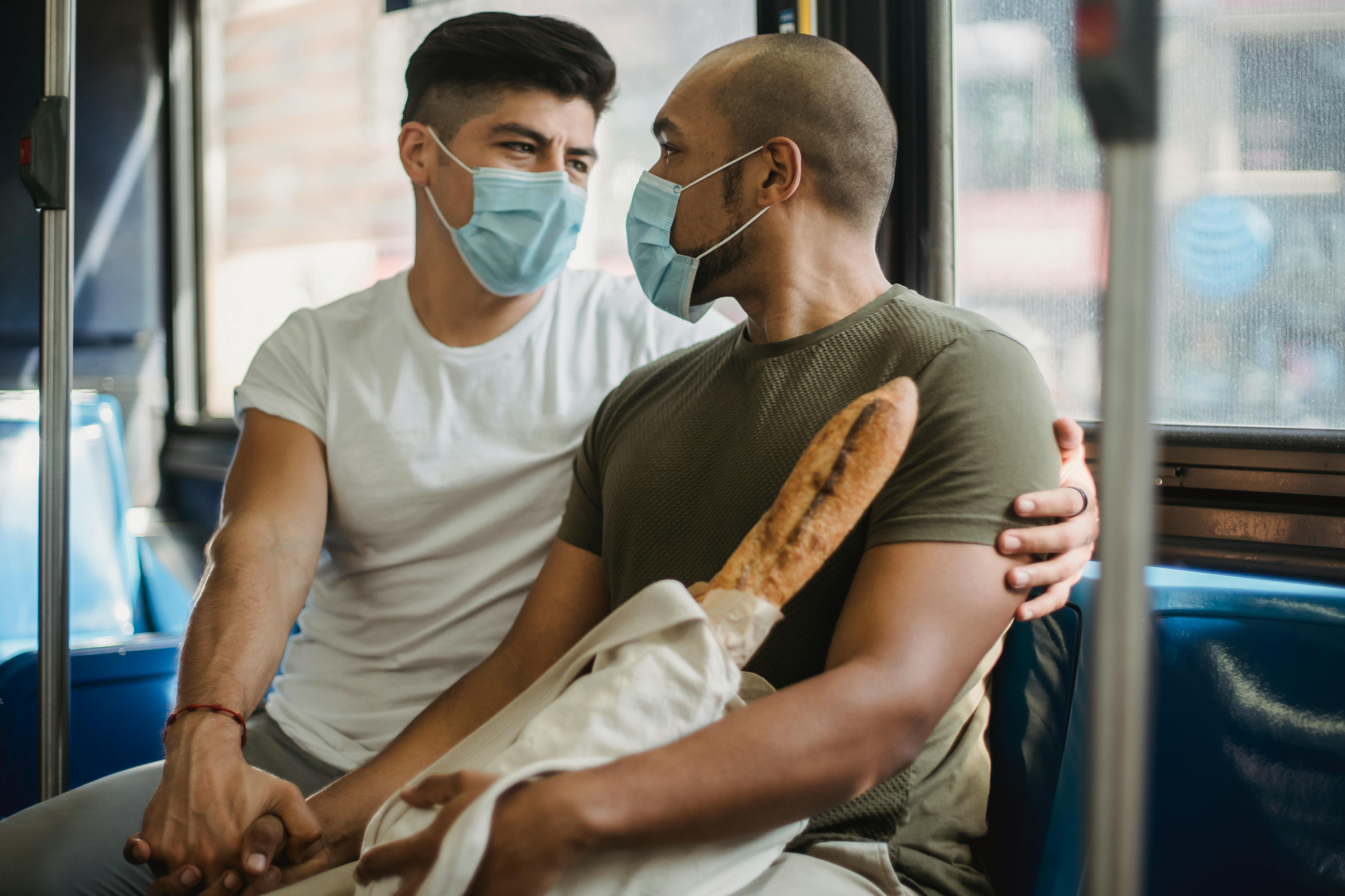 two men with face masks holding hands