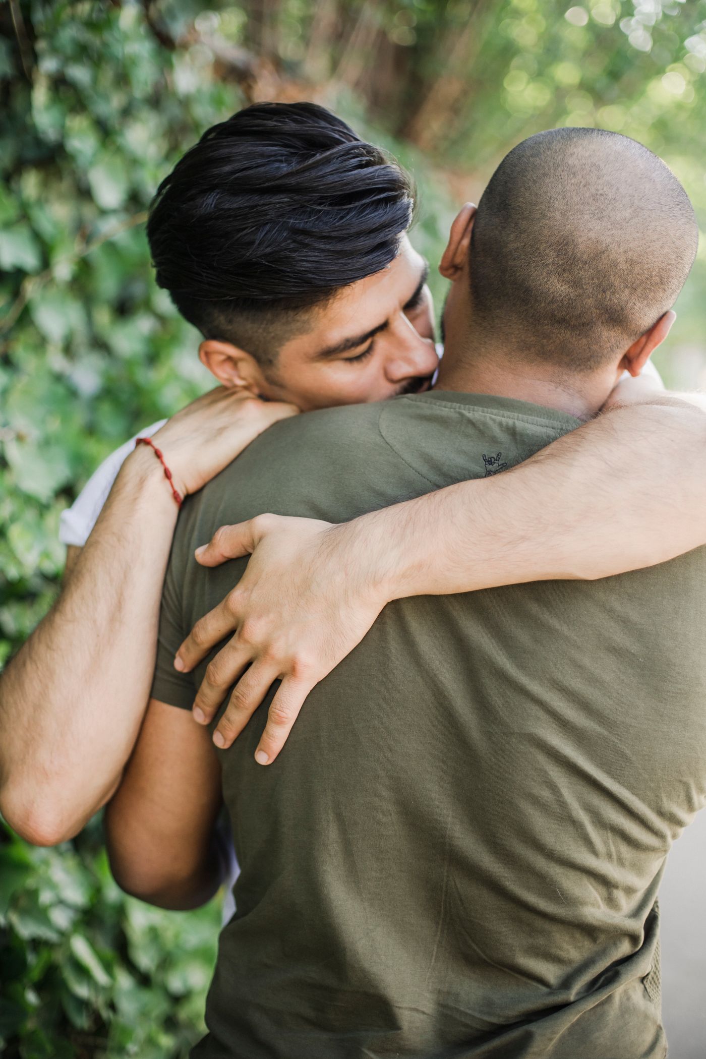 Two men embracing in a warm, natural setting