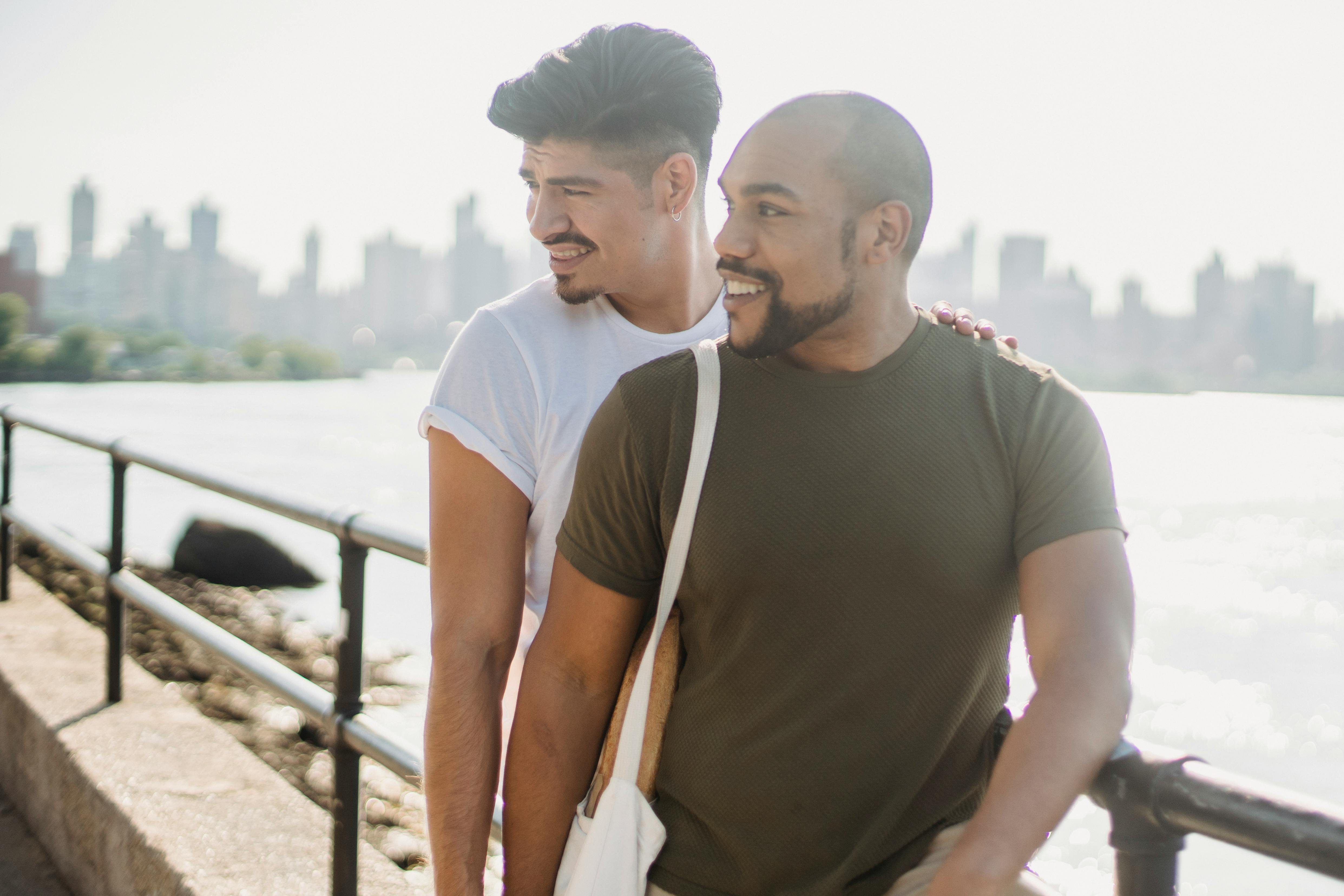 two men standing close to each other looking afar