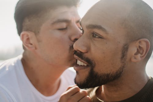 Man Kissing Another Man on the Cheek