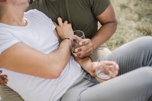 Free Two Men Sitting Together On Grass With Wine Glasses Stock Photo