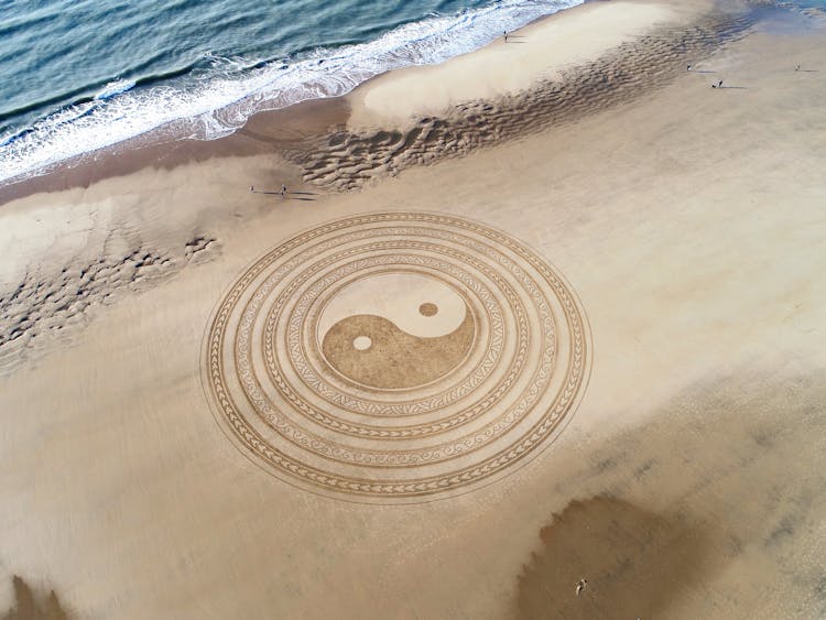 Yin Yang Symbol On Brown Beach Sand