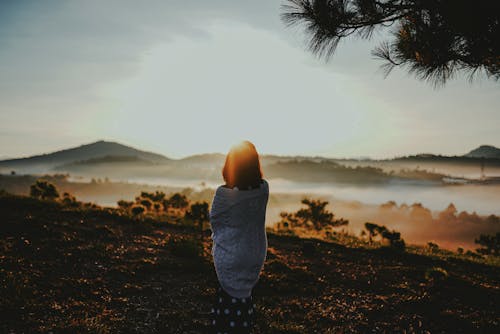 Woman Standing on a Mountain Looking At a Scenery