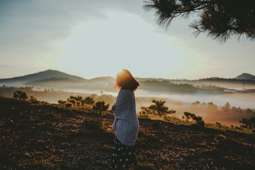 Woman Standing On Mountain Feeling Cold