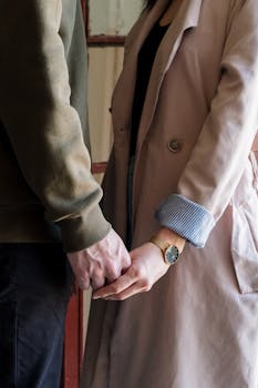 一对情侣手牵着手站在室内，象征着爱与联系