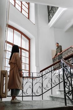 夫妇在时尚楼梯上互动，楼梯位于优雅明亮的室内空间