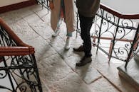 一对夫妇站在配有铸铁栏杆的室内复古石楼梯上，营造出浪漫时尚的氛围