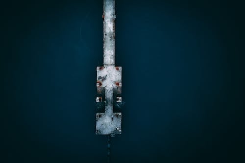 Drone view of peaceful scenery of metal quay located in calm water of dark blue sea