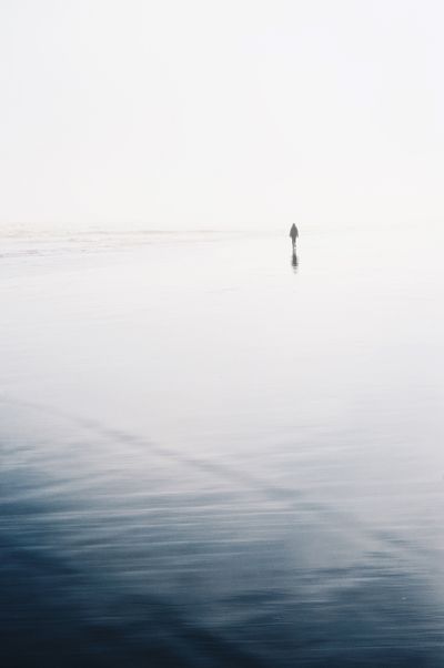 A lone figure walking a quiet beach — photo by Esteban Amaro on Pexels