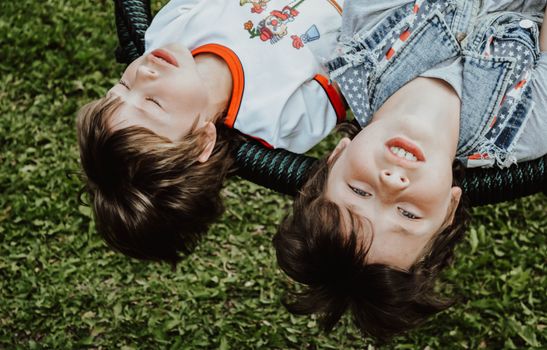 Content boys lying on swings