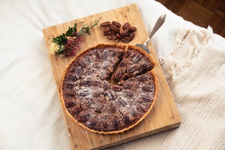 A Pecan Pie On Brown Wooden Chopping Board