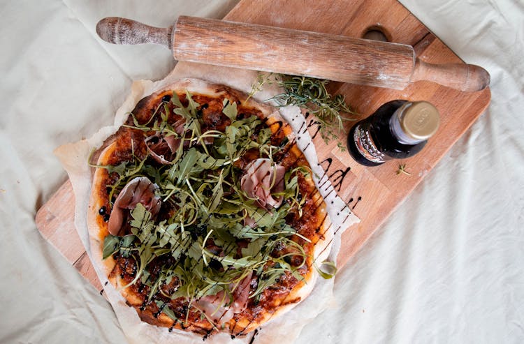 Prosciutto Pizza On Wooden Chopping Board